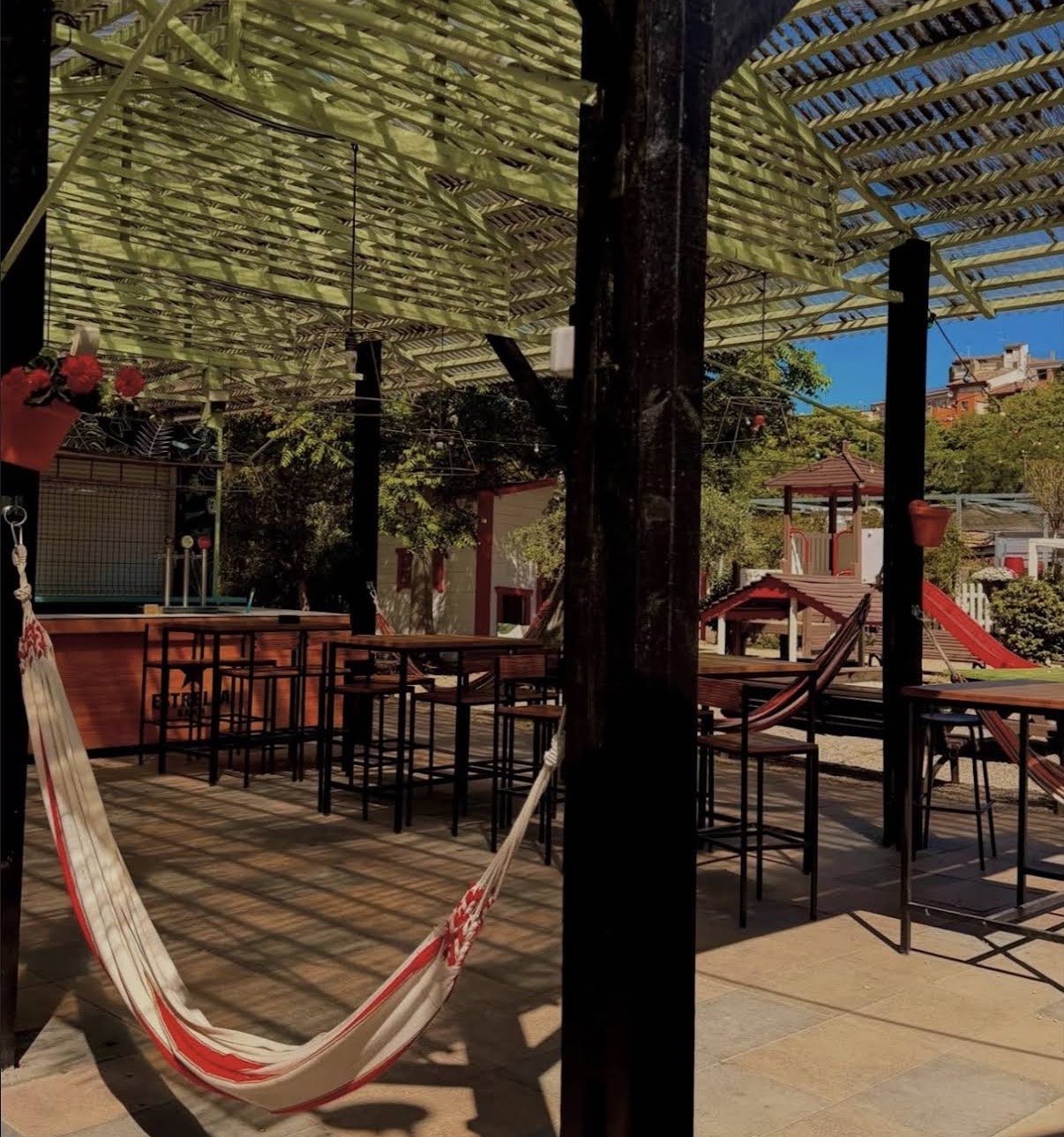 Hamaca y mesas bajo la pérgola de nuestra terraza
